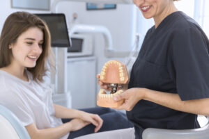 close-up-dentist-showing-teeth-model-smiling-patient