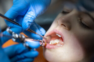 Girl in the dentist’s office. Dentist examining child patient’s teeth. Dentistry concept.