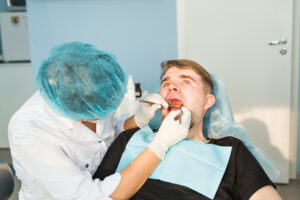 Dental care Concept. Dental inspection is being given to beautiful man surrounded by dentist