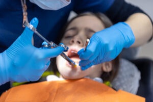 A young woman is giving anesthesia to a tooth. Dental treatment concept.